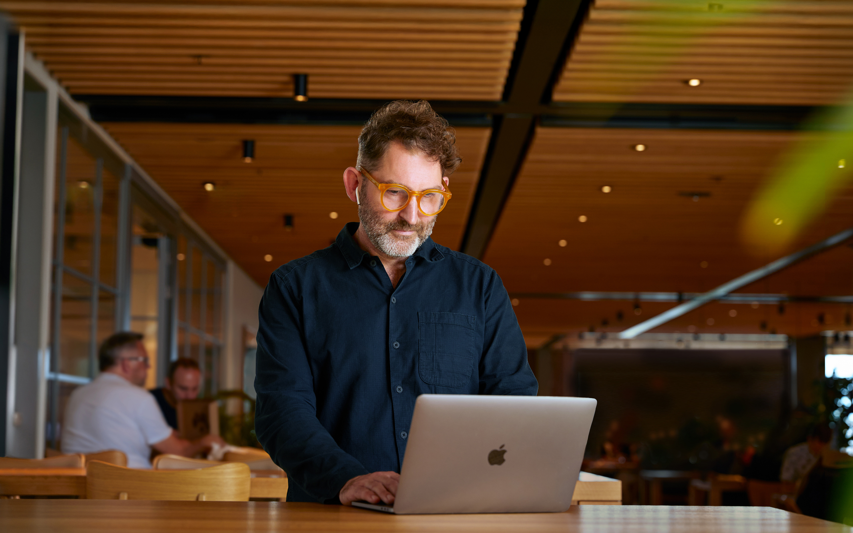 Een Apple medewerker met een Corporate-functie die in een Caffè Macs aan het werk is op een MacBook.