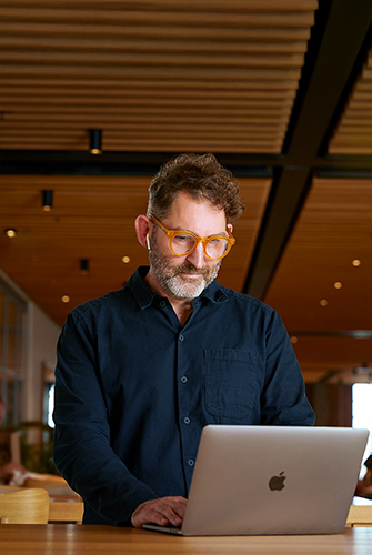 Un membre de l’équipe Apple Fonctions Corporate utilise un MacBook au Caffè Macs.
