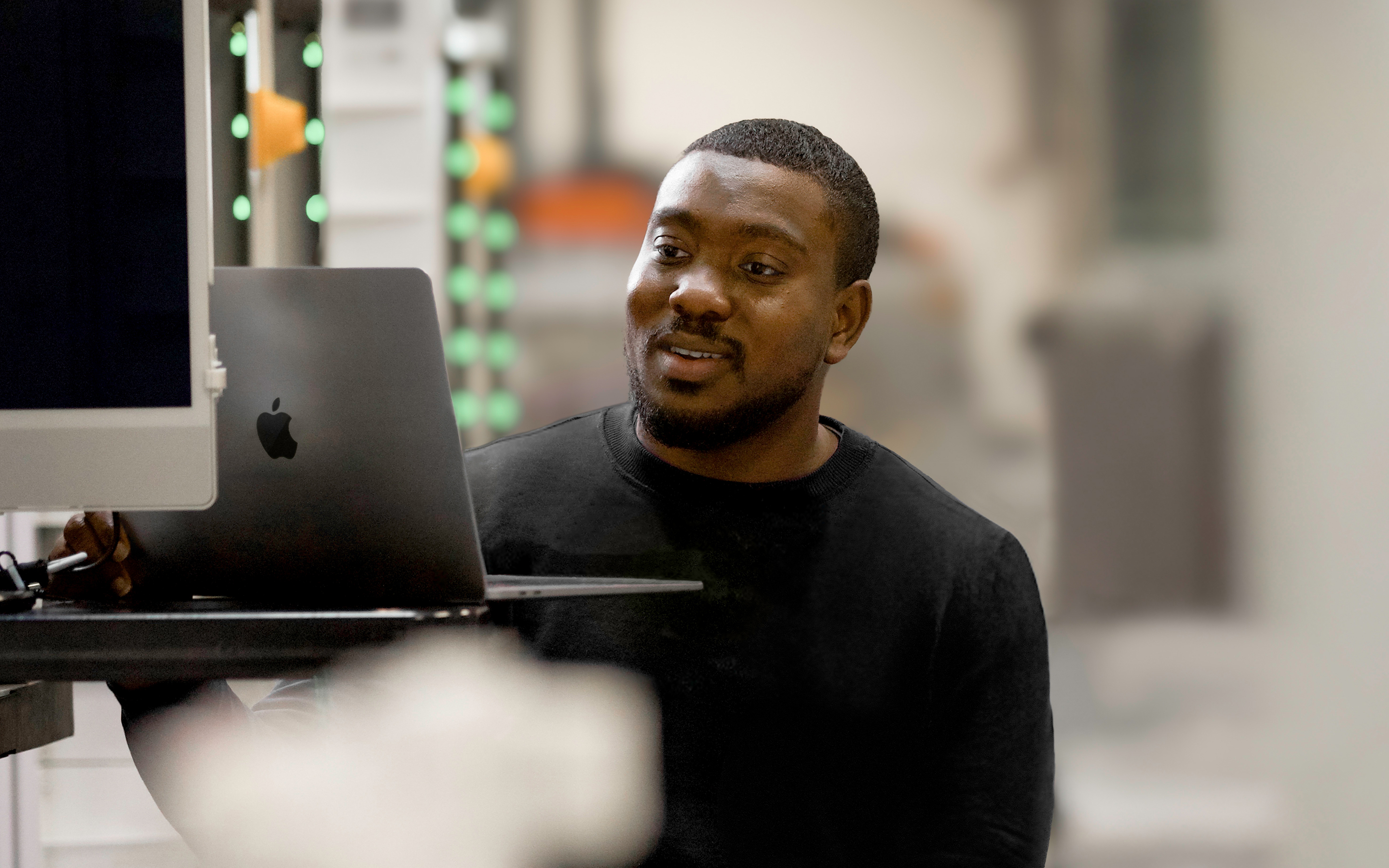 An Apple Operations and Supply Chain team member working on a MacBook.