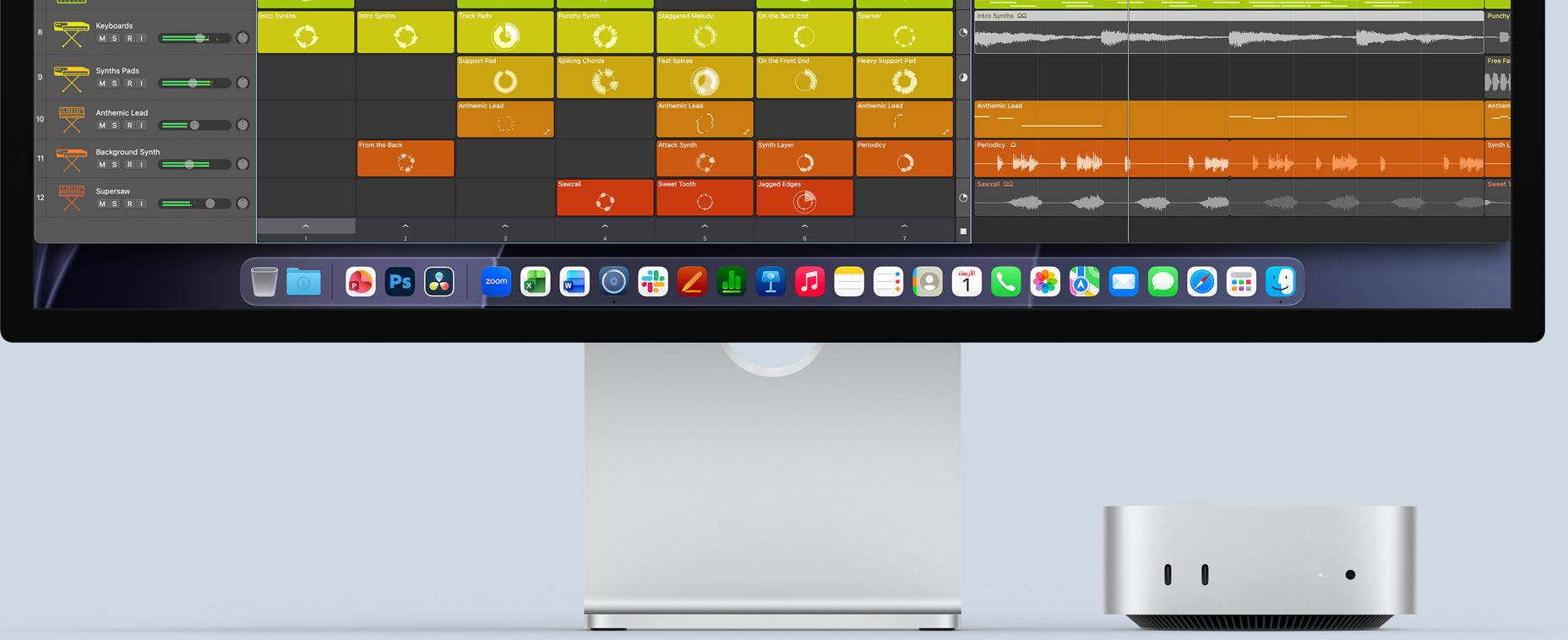 الجهة الأمامية لجهاز Mac mini، موضوع تحت شاشة Studio Display، مع واجهة تطبيق Logic Pro على الشاشة، وتطبيقات الإنتاجية في شريط الأيقونات في الأسفل