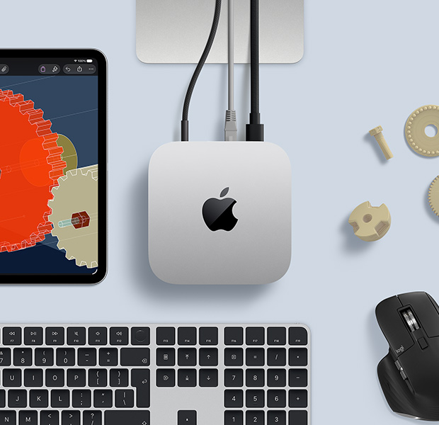 iPad displaying detailed STEM objects, Mac mini central with power cable attached, Studio Display stand partially visible, connected via USB-C, Magic Keyboard with Touch ID, and Logitech mouse