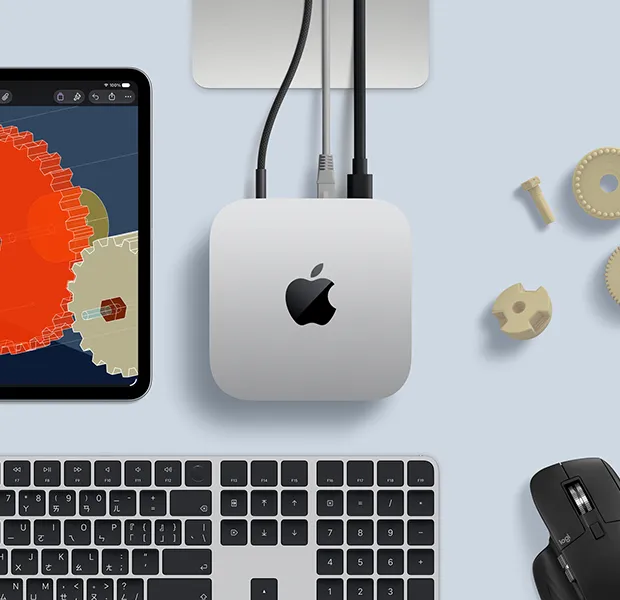 iPad 展示細節豐富的 STEM 物件，Mac mini 位於中央，吸附著電源線，Studio Display 支架部分可見，以 USB-C 連接 Mac mini，旁邊放著含 Touch ID 的巧控鍵盤和 Logitech 滑鼠